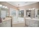Bright bathroom with soaking tub, chandelier, and dual vanities at 9423 Belmont Ln, Marvin, NC 28173