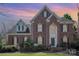 Elegant two-story brick home featuring a grand entrance, arched windows, and manicured landscaping at 9423 Belmont Ln, Marvin, NC 28173