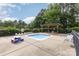 A well-maintained kiddie pool with a small pergola and seating, surrounded by greenery and fencing at 9423 Belmont Ln, Marvin, NC 28173