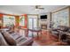 Inviting living room with hardwood floors, fireplace, plush leather furniture, and a bright, open layout at 9423 Belmont Ln, Marvin, NC 28173