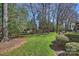 Spacious backyard with manicured lawn, mature trees, and a wrought iron fence at 9627 Baileywick Rd, Charlotte, NC 28277