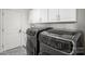 Well-equipped laundry room featuring modern appliances, white cabinetry, and stylish tile flooring at 9627 Baileywick Rd, Charlotte, NC 28277