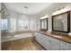The main bath includes a soaking tub, granite counters with dual sinks, and tiled floor at 9627 Baileywick Rd, Charlotte, NC 28277