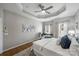 Inviting main bedroom featuring tray ceilings, hardwood floors, a ceiling fan, and decorative wall art at 9627 Baileywick Rd, Charlotte, NC 28277