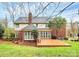 Backyard view featuring a wooden deck with outdoor furniture, lush lawn, and mature trees at 9800 Deer Brook Ln, Charlotte, NC 28210
