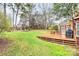 Backyard view featuring a multi-tiered wooden deck, a lush lawn, and mature trees at 9800 Deer Brook Ln, Charlotte, NC 28210