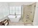 Bright bathroom showcasing a soaking tub, tiled shower, and modern fixtures at 9800 Deer Brook Ln, Charlotte, NC 28210