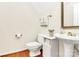 Half bathroom featuring hardwood floors, and a pedestal sink at 9800 Deer Brook Ln, Charlotte, NC 28210