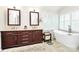 Bright bathroom featuring soaking tub, glass shower, and double vanity with dark wood at 9800 Deer Brook Ln, Charlotte, NC 28210