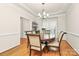 Formal dining room with hardwood floors, elegant lighting, and seating for six at 9800 Deer Brook Ln, Charlotte, NC 28210