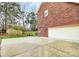 Spacious concrete driveway leading to an attached two-car garage, surrounded by mature trees at 9800 Deer Brook Ln, Charlotte, NC 28210