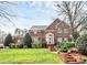 Elegant two-story brick home with manicured lawn and charming architectural details at 9800 Deer Brook Ln, Charlotte, NC 28210