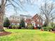 Beautiful brick home with dormers and a well-manicured lawn and landscaping at 9800 Deer Brook Ln, Charlotte, NC 28210