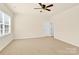 Spacious bedroom with large window, neutral carpet, ceiling fan and ensuite bathroom entrance at 982 Old Trace Nw Rd, Concord, NC 28027