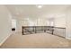 Bright open loft area featuring a wooden railing and neutral carpeting at 982 Old Trace Nw Rd, Concord, NC 28027