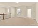 Loft area with window view, neutral carpeting, and attractive dark wood railing at 982 Old Trace Nw Rd, Concord, NC 28027