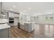 Bright, open kitchen featuring an island, white cabinets, and stainless steel appliances open to the living area at 9932 Manor Vista Trl, Kannapolis, NC 28027