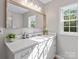 Bright bathroom featuring a large mirror, quartz countertop, and outside window with a view at 105 S York St, Lancaster, SC 29720