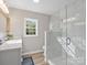 This bathroom has marble tile in the shower, a large mirror, and a view of the trees outside at 105 S York St, Lancaster, SC 29720