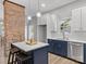 Modern kitchen featuring navy blue cabinets, stainless steel appliances, a brick accent wall, and a center island at 105 S York St, Lancaster, SC 29720