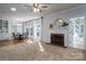 Open living room features a fireplace, carpeted floors, and access to a formal dining area and sunroom at 107 Doris Ct, Lincolnton, NC 28092