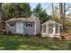 Backyard featuring two outbuildings: a storage shed with double doors and a charming greenhouse with glass panels at 107 Doris Ct, Lincolnton, NC 28092