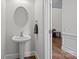 Bathroom featuring pedestal sink, round mirror, and elegant trim at 109 Stirling Heights Ln, Fort Mill, SC 29715