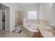Bright bathroom featuring a soaking tub, a glass-enclosed shower, and a double-hung window at 109 Stirling Heights Ln, Fort Mill, SC 29715