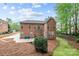 Brick home's backyard featuring a patio, well-maintained lawn and mature trees at 109 Stirling Heights Ln, Fort Mill, SC 29715