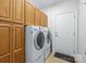 Well-organized laundry room with a front-load washer and dryer set, along with built-in cabinets for storage at 109 Stirling Heights Ln, Fort Mill, SC 29715