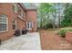 Brick home featuring a stone patio with a grill and access to a spacious, landscaped backyard at 109 Stirling Heights Ln, Fort Mill, SC 29715