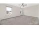 Large bedroom featuring a ceiling fan, two windows offering ample natural light, and neutral-toned walls and carpet at 1178 Valley St, Statesville, NC 28677