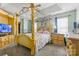 Primary bedroom featuring a four-poster bed, tray ceiling, and natural light at 11834 Mallard Ridge Dr, Charlotte, NC 28269