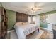 Stylized bedroom with a cozy bed, ceiling fan, an accent wall, and easy access to an en-suite bathroom at 1310 Seneca Pl, Charlotte, NC 28209
