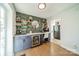 Bright home office with custom cabinets, beverage cooler, open shelving, and modern lighting at 1310 Seneca Pl, Charlotte, NC 28209