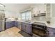 Modern kitchen with white subway tile, stainless steel appliances, and white and purple cabinets at 1310 Seneca Pl, Charlotte, NC 28209