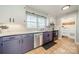 Well-lit kitchen featuring stainless steel appliances and stylish white and purple cabinets at 1310 Seneca Pl, Charlotte, NC 28209