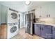 Convenient laundry area with stacked washer/dryer, stainless steel refrigerator, and storage cabinets at 1310 Seneca Pl, Charlotte, NC 28209