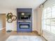 Bright living room features a fireplace with TV, built-in shelving, large windows, and hardwood floors at 1310 Seneca Pl, Charlotte, NC 28209