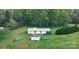 Aerial view of home with a metal roof, a small shed, and a spacious lawn surrounded by trees at 137 Beaverbrook Rd, Statesville, NC 28677