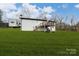 Spacious backyard with green grass and a wooden deck accessible by stairs at 17154 Frog Pond Rd, Oakboro, NC 28129