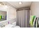 Compact bathroom featuring a toilet, mirror, and a shower with a grey shower curtain at 17154 Frog Pond Rd, Oakboro, NC 28129