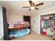 Bright bedroom featuring a bunk bed, ceiling fan, and closet filled with clothes and accessories at 17154 Frog Pond Rd, Oakboro, NC 28129