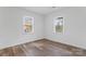 Light and airy bedroom features two windows and wood-look flooring at 1826 Taylor Ave, Charlotte, NC 28216