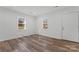 Bright room featuring new laminate flooring and white painted walls adjacent to the front door and large windows at 1826 Taylor Ave, Charlotte, NC 28216