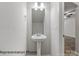 Tastefully designed powder room features pedestal sink, sleek fixtures, and clean, modern aesthetics at 2021 Mcdonald Dr, Charlotte, NC 28216