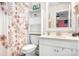 Bright bathroom features a floral shower curtain and white fixtures at 2024 Linn Cv, Waxhaw, NC 28173
