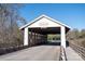 Charming white covered bridge with wooden accents on a sunny day, inviting exploration and peaceful scenery at 2024 Linn Cv, Waxhaw, NC 28173
