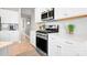 Well-equipped kitchen featuring stainless steel oven, microwave, white cabinetry, and bright lighting at 2024 Linn Cv, Waxhaw, NC 28173