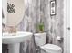 Stylish powder room with geometric wallpaper, a pedestal sink, and modern fixtures at 2024 Linn Cv, Waxhaw, NC 28173